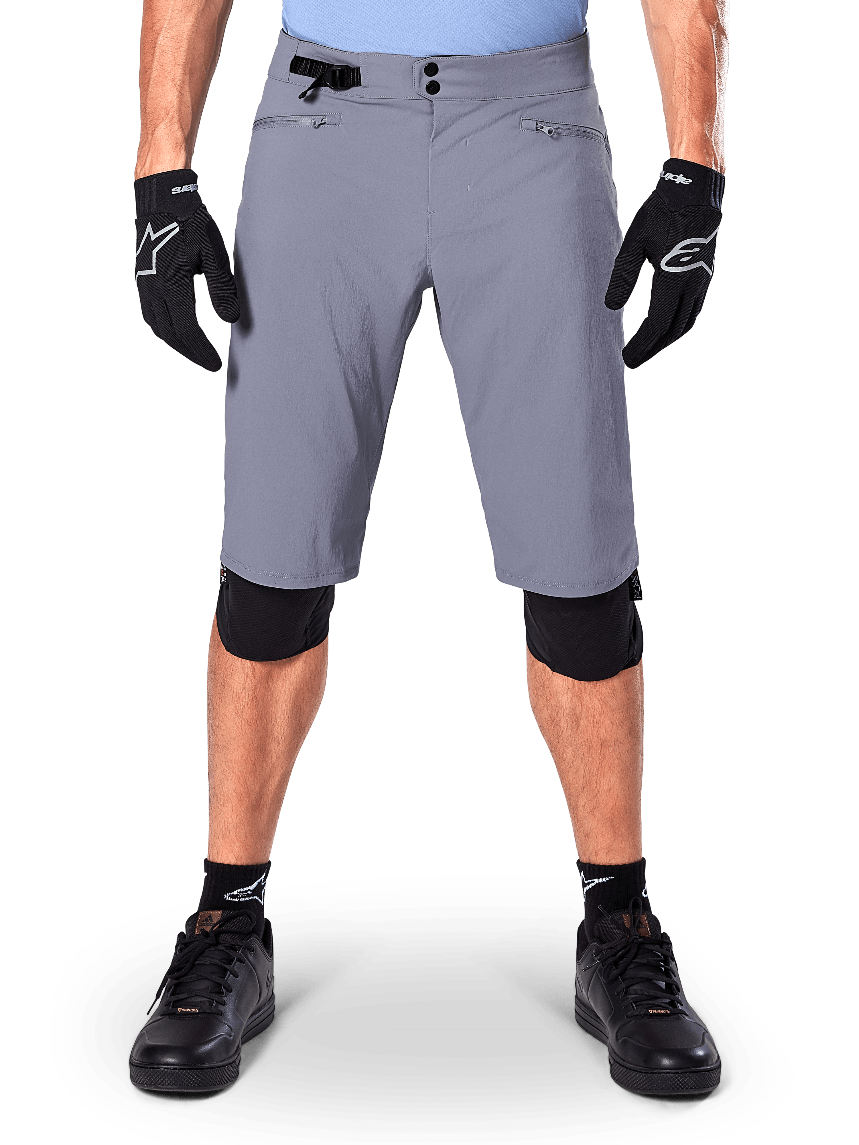 Alpinestars A-Dura Shorts, mountainbikeshorts, mörkgrå, bärs med svarta Alpinestars-handskar och knäskydd, med dubbel tryckknappsstängning och dragkedjeförsedda nätfodrade fickor, slitstarkt 2-vägsstretchtyg för terrängcykling