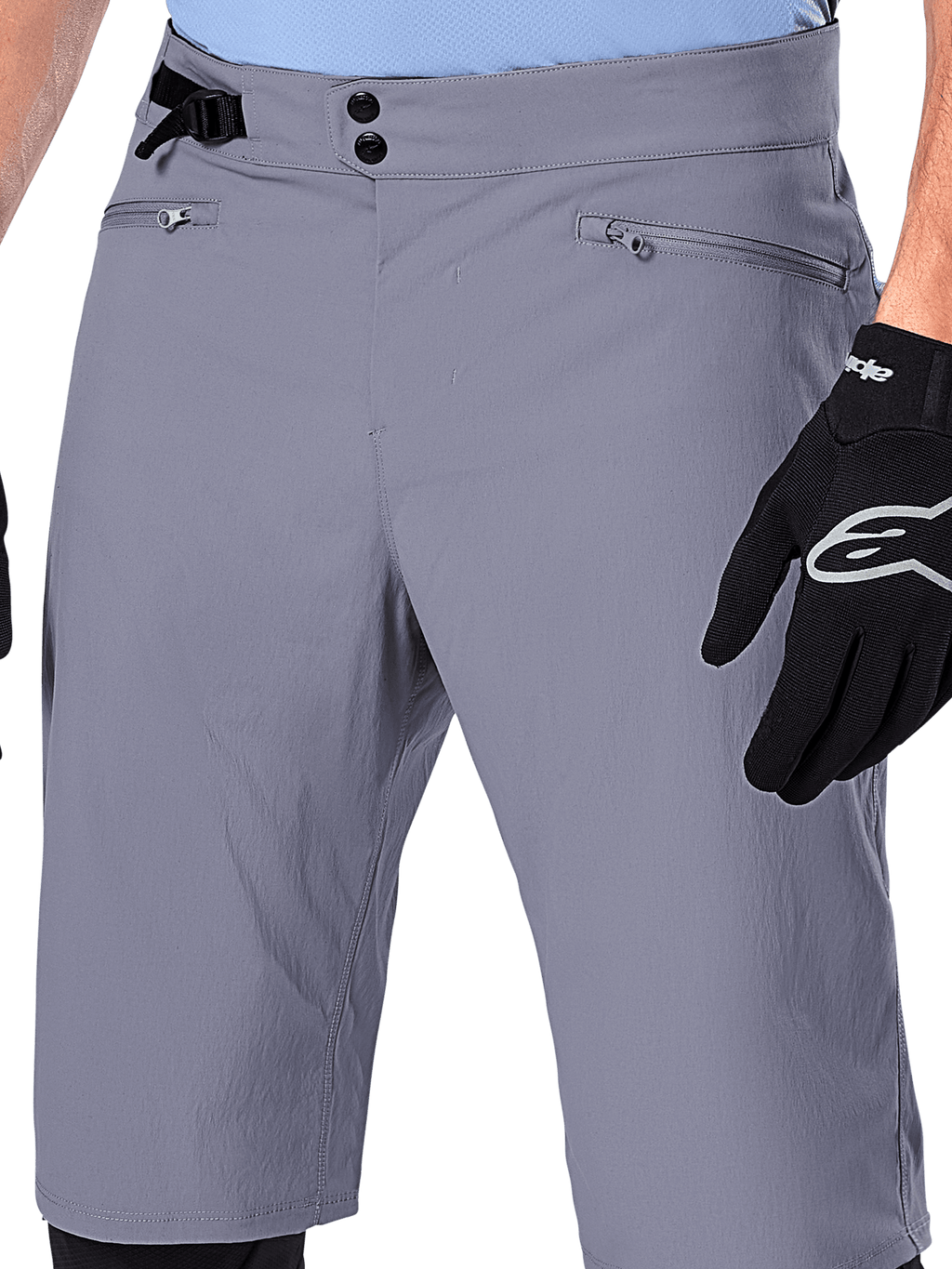 Alpinestars A-Dura Shorts, MTB-shorts, mörkgrå, närbild på midjan som visar dubbla tryckknappar, sidoreglage och dragkedjeförsedda fickor, kombinerat med svarta cykelhandskar, slitstarka mountainbikekläder.
