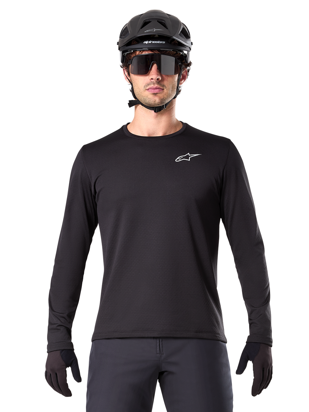 Alpinestars A-Dura Thermal Tröja, svart långärmad mountainbike-tröja, bärs med en svart hjälm och stora solglasögon, liten vit Alpinestars-logotyp på bröstet, normal passform, MTB-cykelkläder