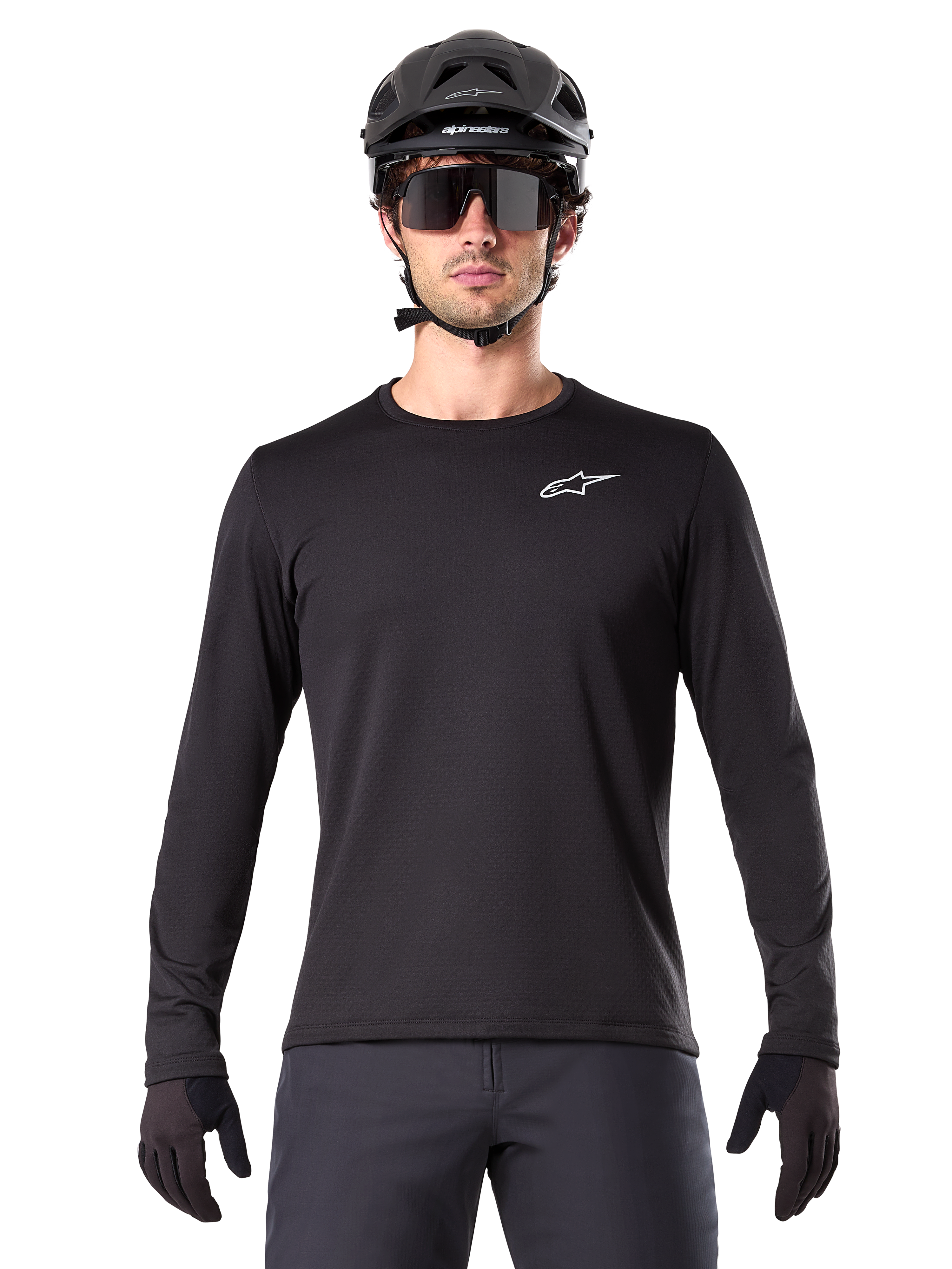 Alpinestars A-Dura Thermal Tröja, svart långärmad mountainbike-tröja, bärs med en svart hjälm och stora solglasögon, liten vit Alpinestars-logotyp på bröstet, normal passform, MTB-cykelkläder