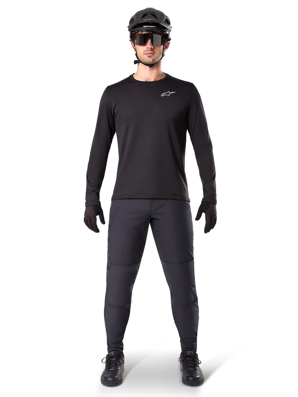 Alpinestars A-Dura Thermal tröja, svart långärmad mountainbiketröja, bärs med mörkgrå byxor, svarta handskar, svart hjälm och solglasögon, med en vit Alpinestars-logotyp på bröstet, koordinerad outfit för mountainbike-cykling i kallt väder