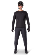 Alpinestars A-Dura Thermal tröja, svart långärmad mountainbiketröja, bärs med mörkgrå byxor, svarta handskar, svart hjälm och solglasögon, med en vit Alpinestars-logotyp på bröstet, koordinerad outfit för mountainbike-cykling i kallt väder