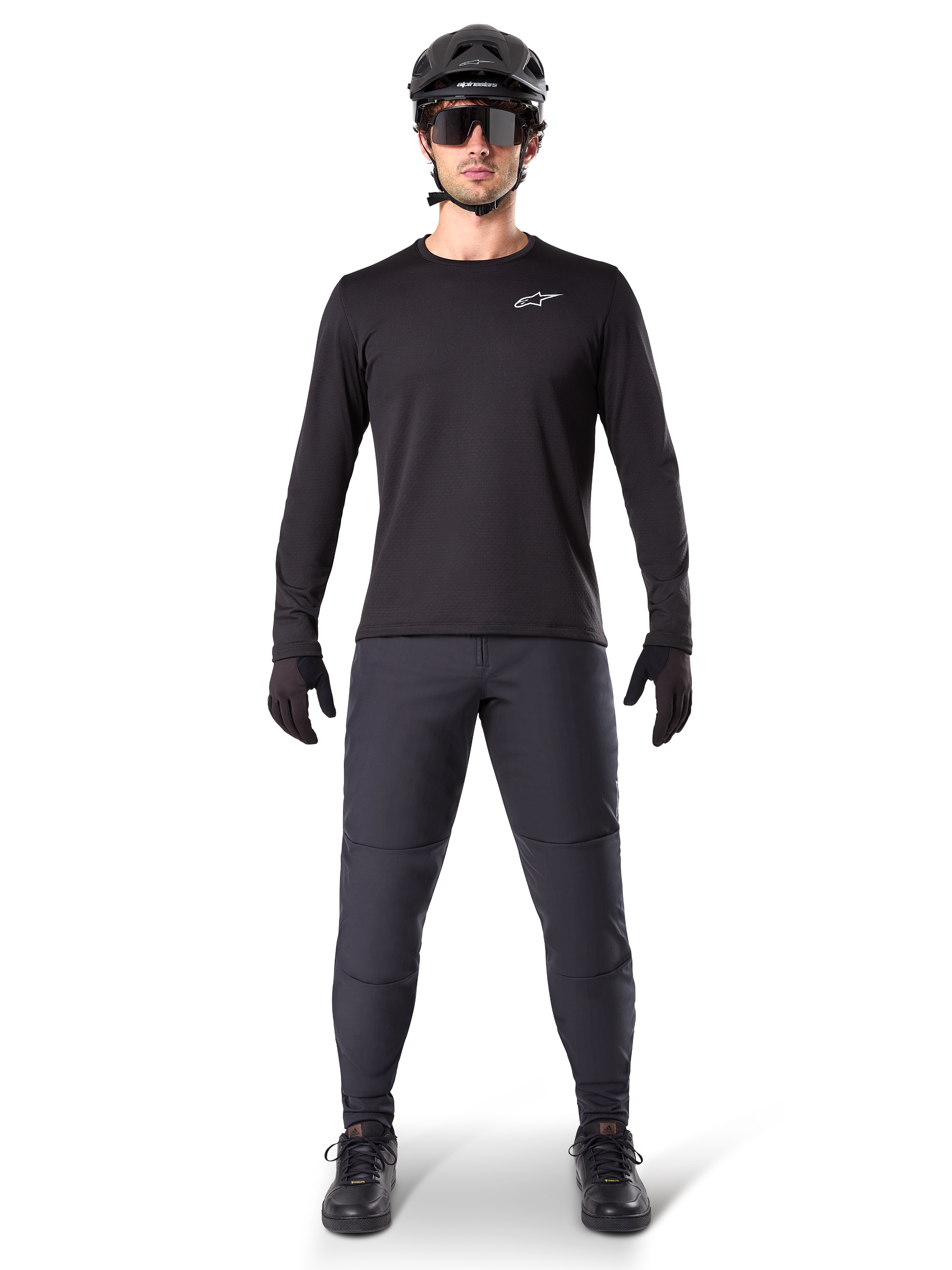 Alpinestars A-Dura Thermal tröja, svart långärmad mountainbiketröja, bärs med mörkgrå byxor, svarta handskar, svart hjälm och solglasögon, med en vit Alpinestars-logotyp på bröstet, koordinerad outfit för mountainbike-cykling i kallt väder