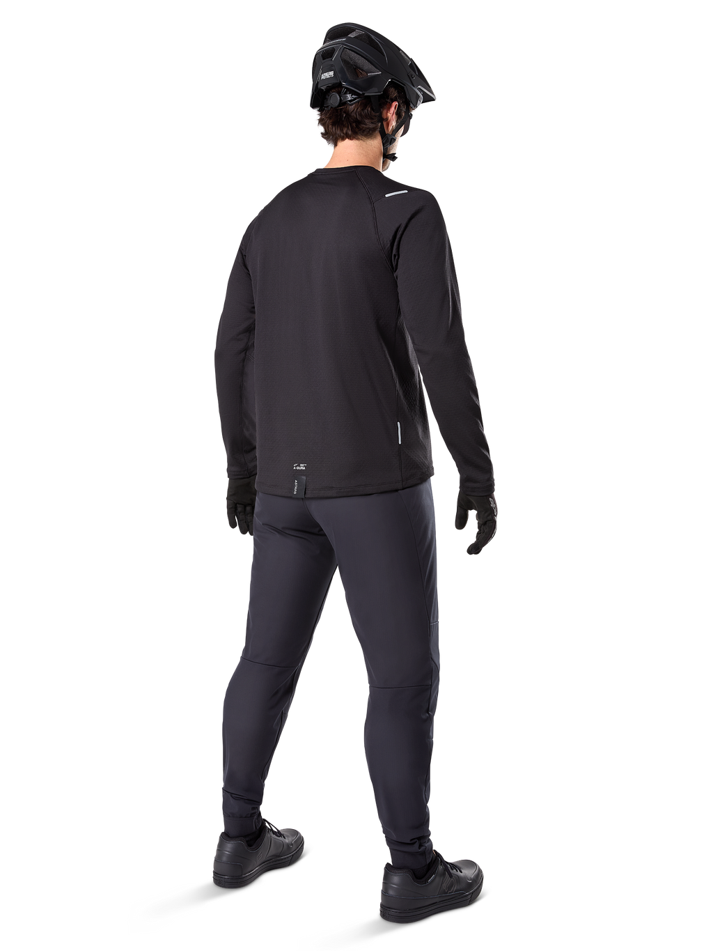 Alpinestars A-Dura Thermal Tröja, långärmad cykeltröja för herrar, svart, vy bakifrån på modell med svart MTB-hjälm, mörkgrå byxor och svarta handskar, professionella mountainbike-kläder för kallt väder