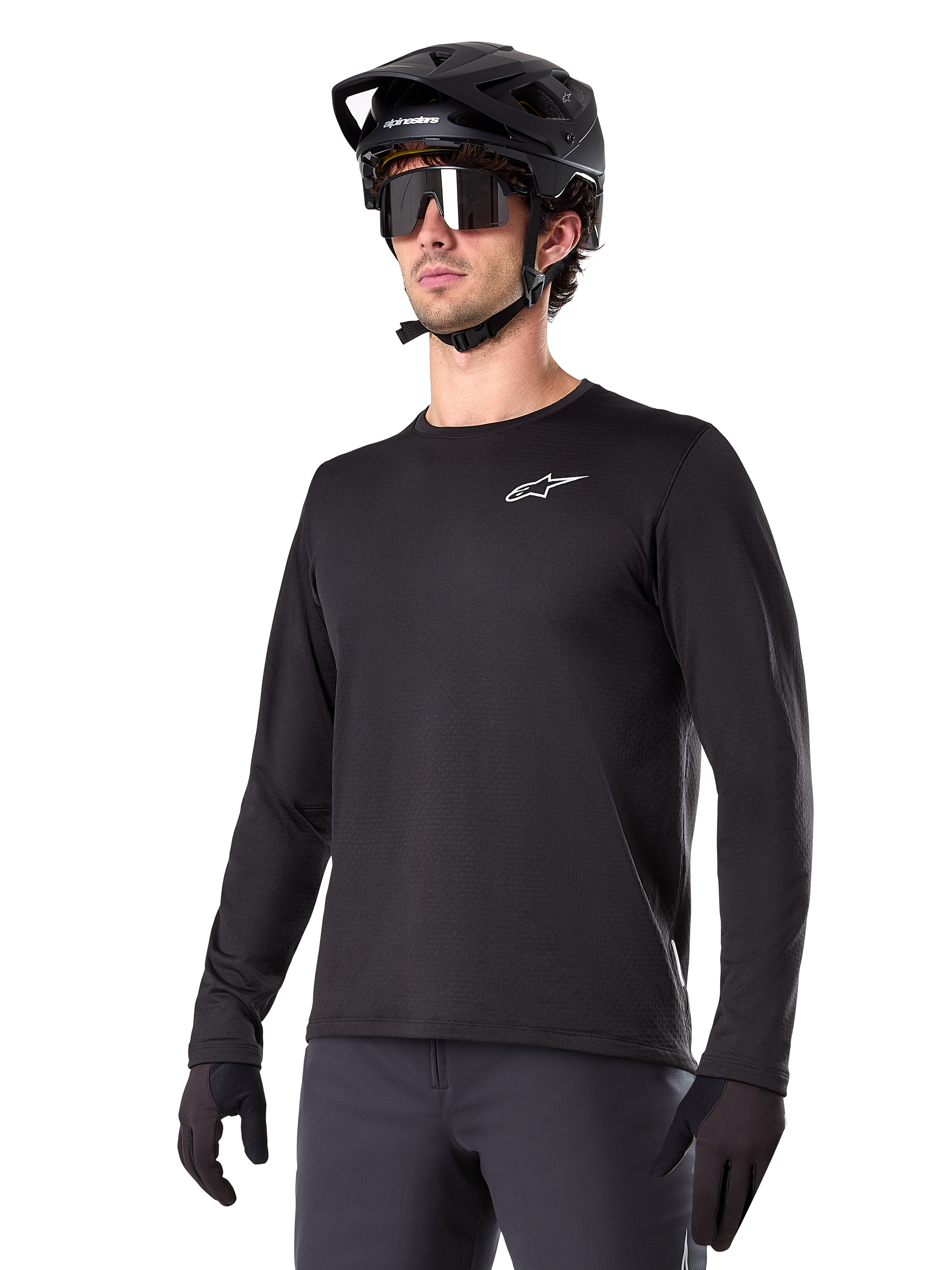 Alpinestars A-Dura Thermal Jersey, svart långärmad mountainbiketröja, vit logotyp på bröstet, bärs med svart hjälm och handskar, stilren sportig design för trailcykling