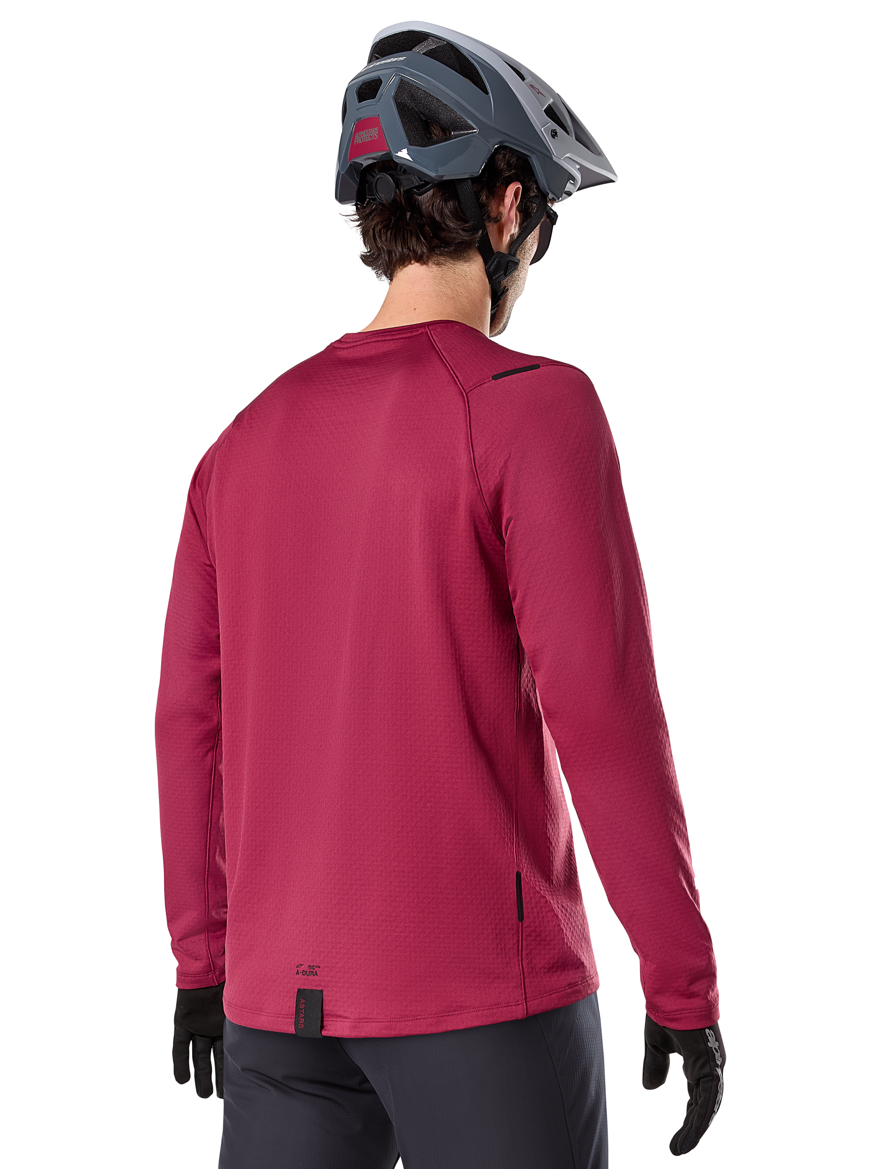 Alpinestars A-Dura Thermal Jersey, långärmad mountainbiketröja, vinröd, baksida på modell med grå MTB-hjälm och svarta handskar, förlängt ryggparti och små logotypdetaljer, designad för trailcykling i kallt väder