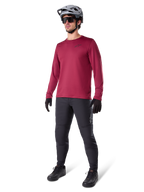 Alpinestars A-Dura Thermal Jersey i vinrött, långärmad isolerad cykeltröja bärs med mörkgrå mountainbikebyxor, svarta handskar och en grå hjälm, helkroppsbild i studio av MTB-utrustning för kallt väder.