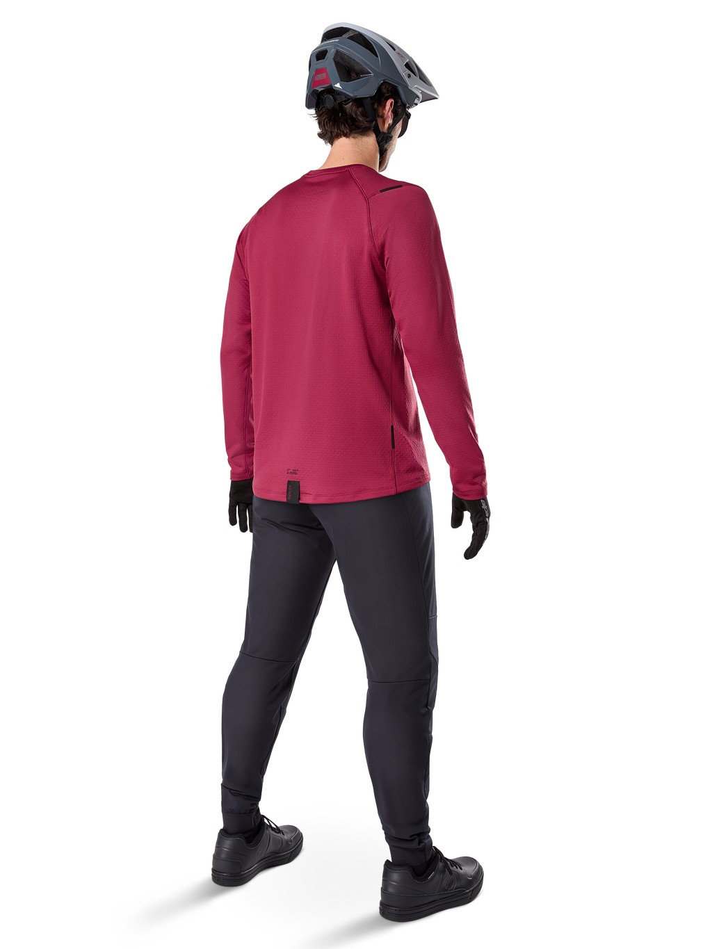 Alpinestars A-Dura Thermal Jersey, vinröd långärmad cykeltröja, vy bakifrån, bärs med svarta mountainbikebyxor och en grå hjälm, förlängd fåll bak för extra täckning, mountainbike-utrustning för kallt väder
