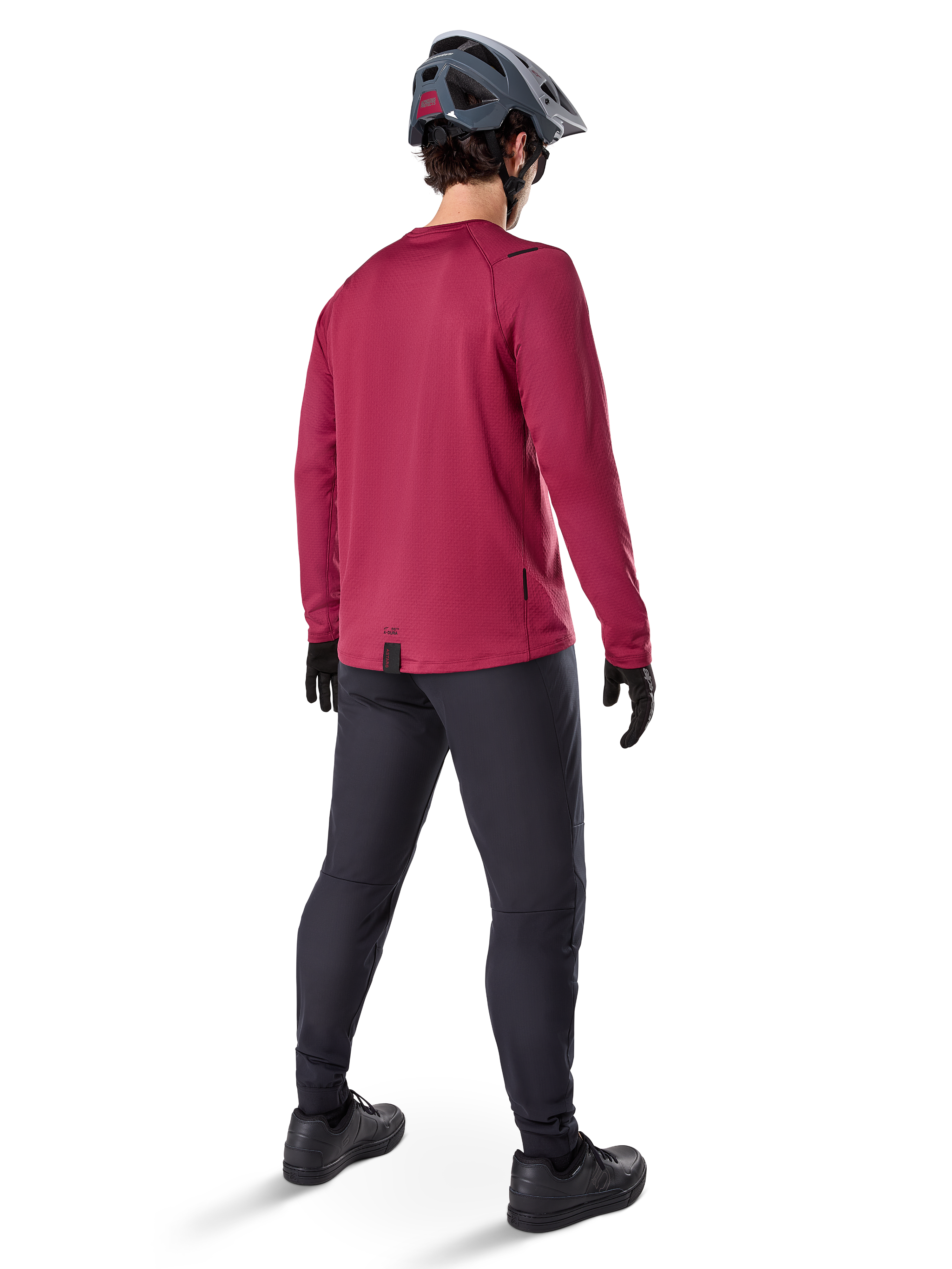 Alpinestars A-Dura Thermal Jersey, vinröd långärmad cykeltröja, vy bakifrån, bärs med svarta mountainbikebyxor och en grå hjälm, förlängd fåll bak för extra täckning, mountainbike-utrustning för kallt väder