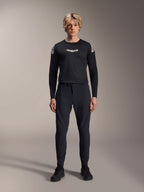Manlig modell som bär Alpinestars A-Aria Polartec Elite långärmad tröja i svart, med en vit Astars-logotyp på bröstet och logotyper på axlarna, kombinerat med svarta tekniska MTB-byxor och skor, prestandautrustning för mountainbike