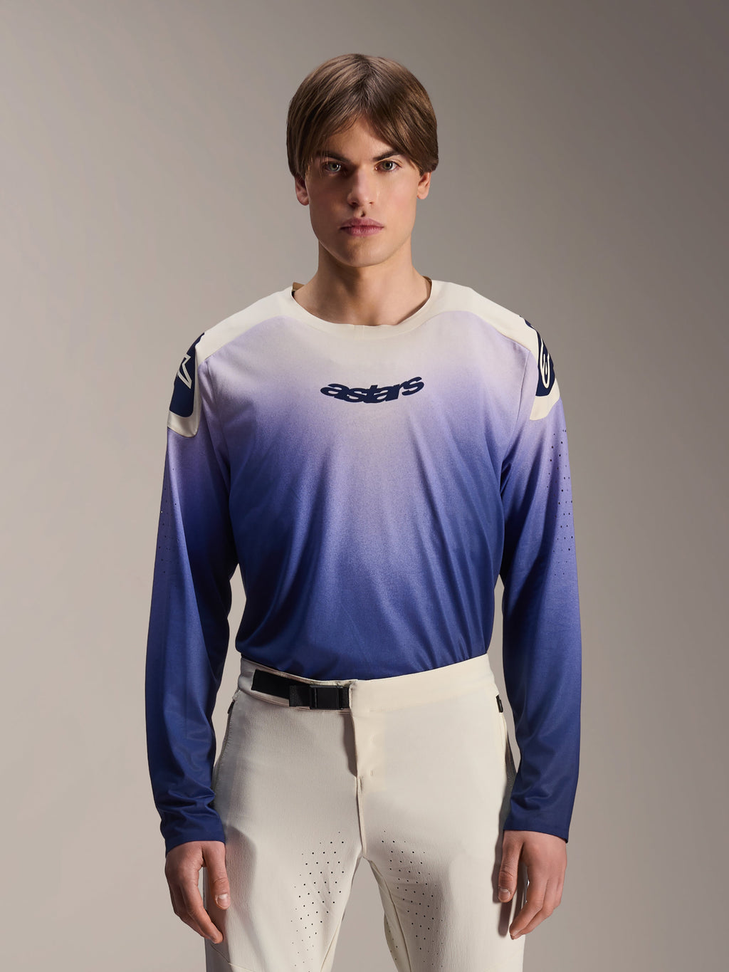 Alpinestars A-Aria Polartec Maker Elite-tröja, långärmad MTB-tröja, Baja Blue med vit-till-blå gradient, bärs av en modell med vita byxor, mörkblå logotyp på bröstet och laserperforeringar på ärmarna, funktionskläder för mountainbike
