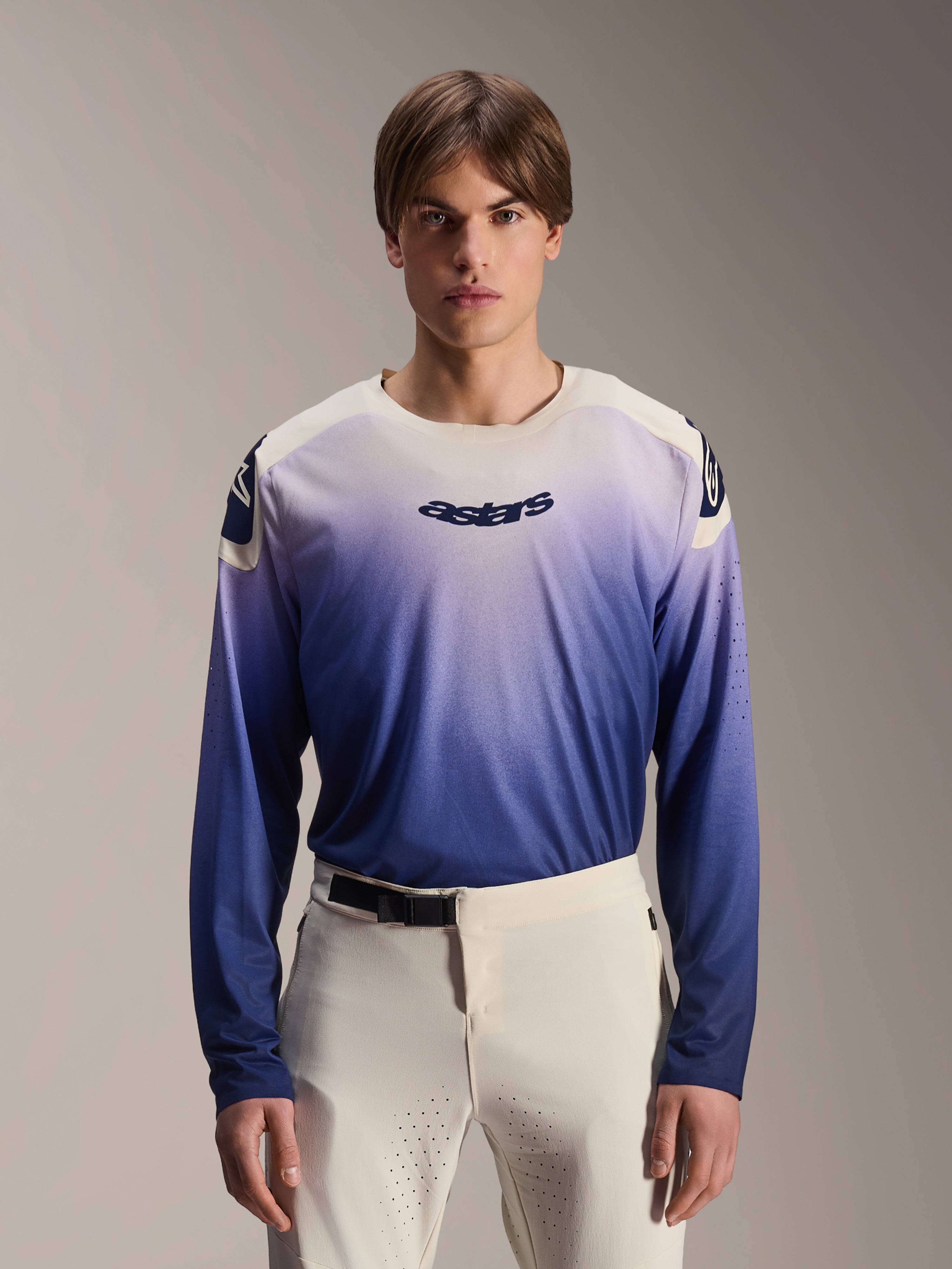 Alpinestars A-Aria Polartec Maker Elite-tröja, långärmad MTB-tröja, Baja Blue med vit-till-blå gradient, bärs av en modell med vita byxor, mörkblå logotyp på bröstet och laserperforeringar på ärmarna, funktionskläder för mountainbike