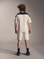 Alpinestars A-Aria Elite Shorts och A-Aria Polartec Elite SS Jersey, Ecru med svarta axelpartier, ryggvy av en modell i mountainbike-utrustning, stylad med svarta strumpor och skor