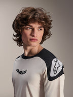 Alpinestars A-Aria Polartec Elite kortärmad tröja, ecru med svarta axelpaneler, svart astars-logotyp på bröstet och vit Astars-logotyp på axeln, högpresterande mountainbike-utrustning buren av modell