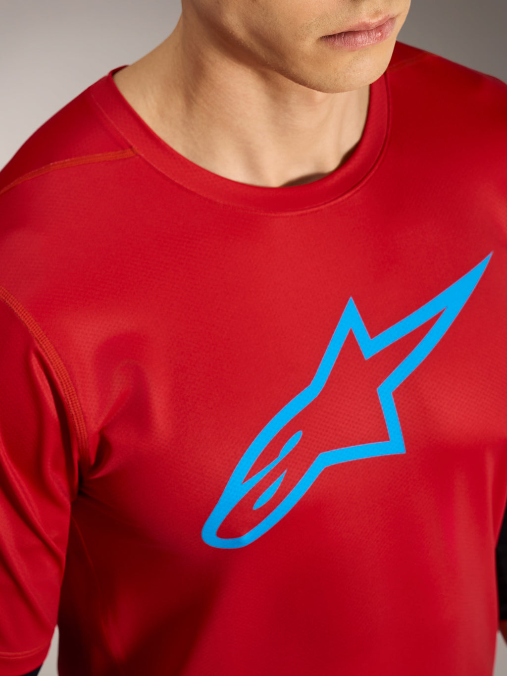 Röd A-Dura Ride kortärmad tröja med blå Alpinestars-logotyp, högpresterande mountainbikekläder.
