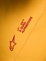 Orange A-Dura Ride-tröja, detalj med röd Alpinestars Astars-logotyp och textlogga screentryckt på stretchtyg.