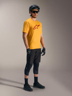 Orange A-Dura Ride kortärmad tröja med röd Astars-logotyp, matchad med svart mountainbike-utrustning och hjälm.