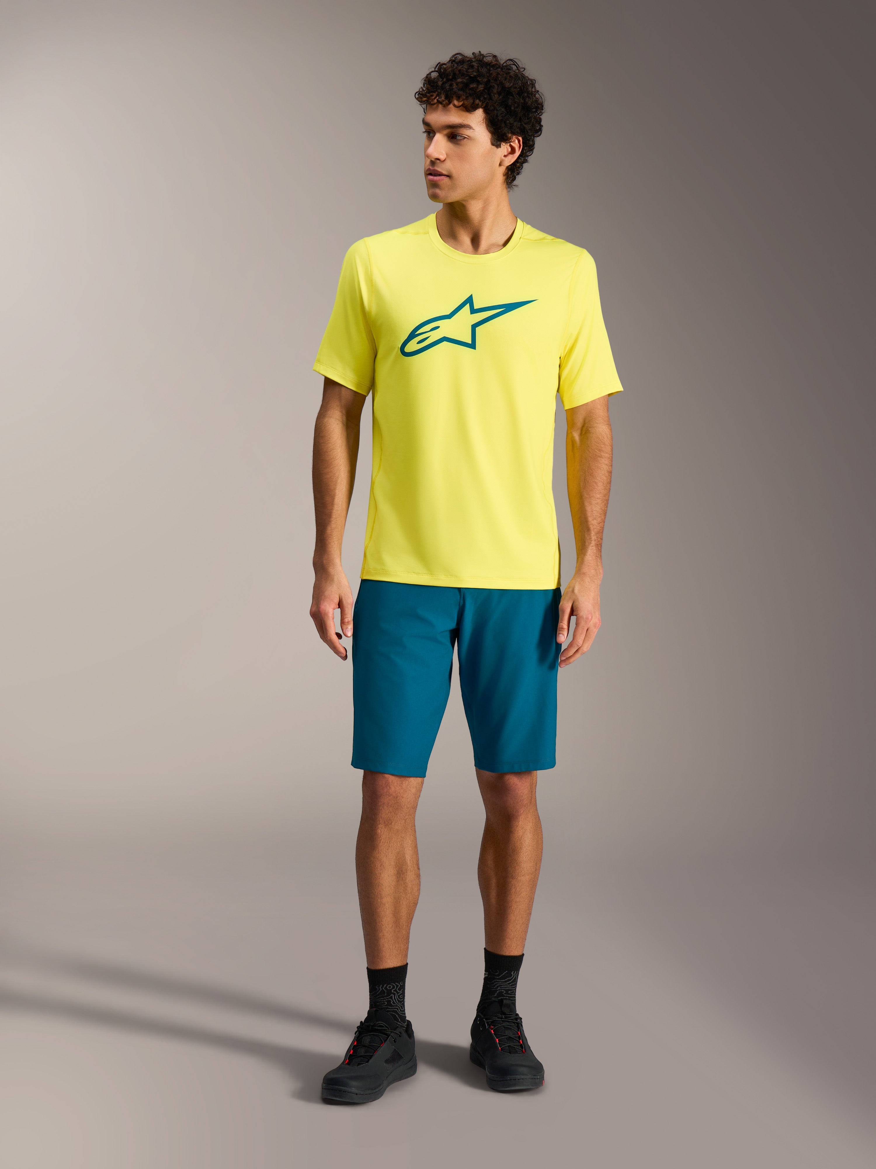 Gul Alpinestars A-Dura Ride SS Jersey och blågröna shorts, tekniska MTB-kläder för herrar i studiomiljö