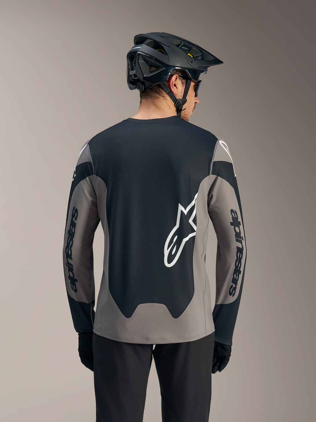 Alpinestars A-Dura Race långärmad tröja i grått och svart med tydliga vita logotyper på ryggen och ärmarna.