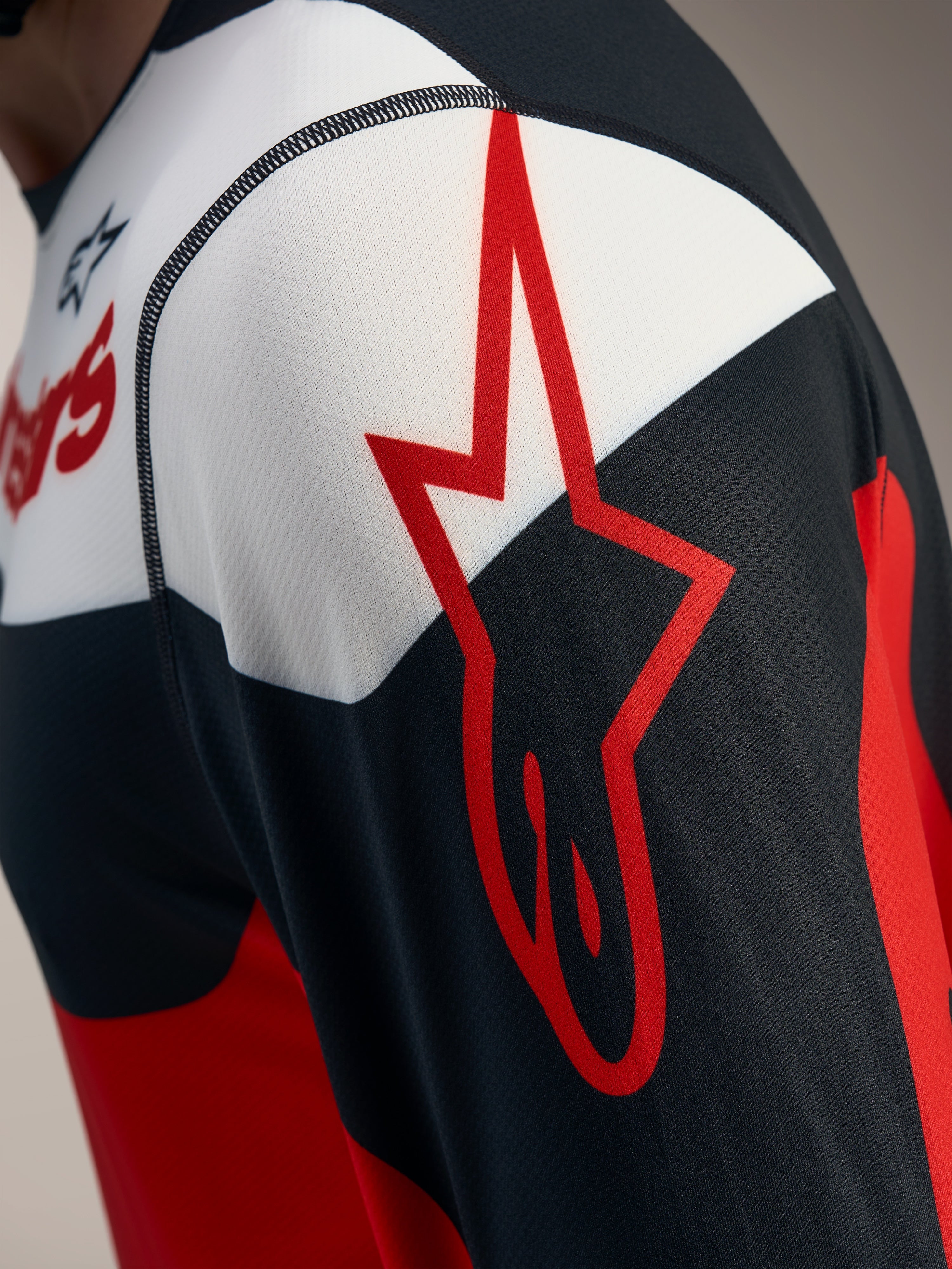 Röd och svart A-Dura Race långärmad tröja med Alpinestars stjärnlogo på ventilerande jacquard-mesh, detaljvy.