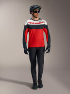 Alpinestars A-Dura Race långärmad tröja, röd med vita och svarta paneler, matchad med svarta MTB-byxor och hjälm.