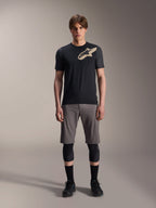 Alpinestars A-Dura Lipan kortärmad tröja, svart med gråmelerade ärmar och beige Astars-logotyp på bröstet, bärs av en manlig modell med grå mountainbikeshorts och svarta knäskydd, funktionell MTB-utrustning.