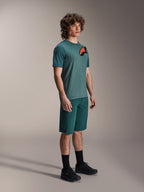 Alpinestars A-Dura Lipan SS Jersey och A-Dura Shorts, MTB-cykeloutfit, Dark Pine, tröja med en stor orange stjärnlogotyp, kombinerat med matchande shorts och svarta skor, högpresterande mountainbike-kläder