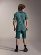 Alpinestars A-Dura Lipan kortärmad tröja i Silver Pine, vy bakifrån som visar de texturerade jacquard-axelpanelerna och det förlängda bakstycket, buren med matchande mörkgröna mountainbikeshorts och svarta skor.