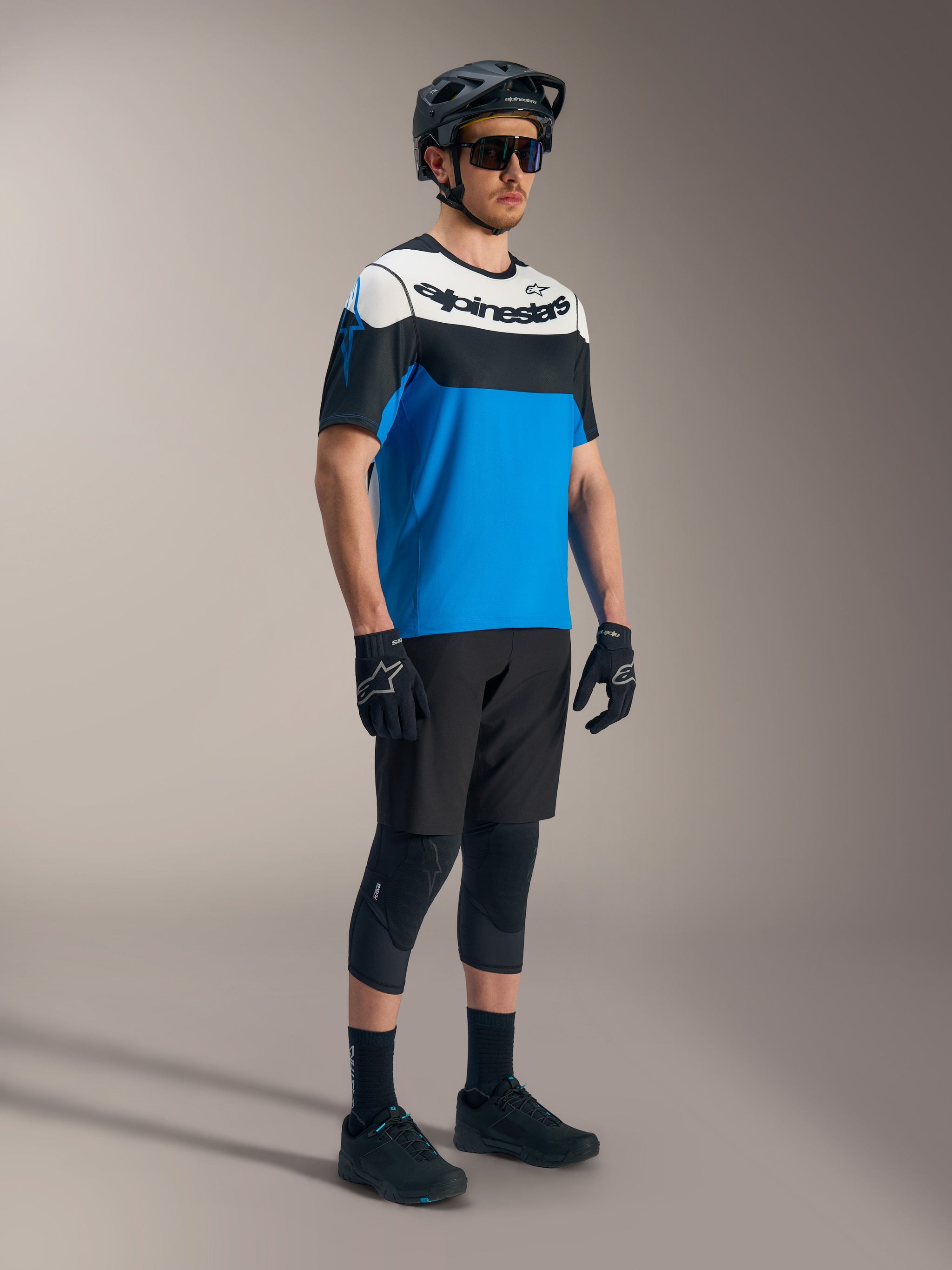 Alpinestars A-Dura Race SS Jersey in blue, black, and white, paired with A-Dura Ride Shorts and MTB protective gear.