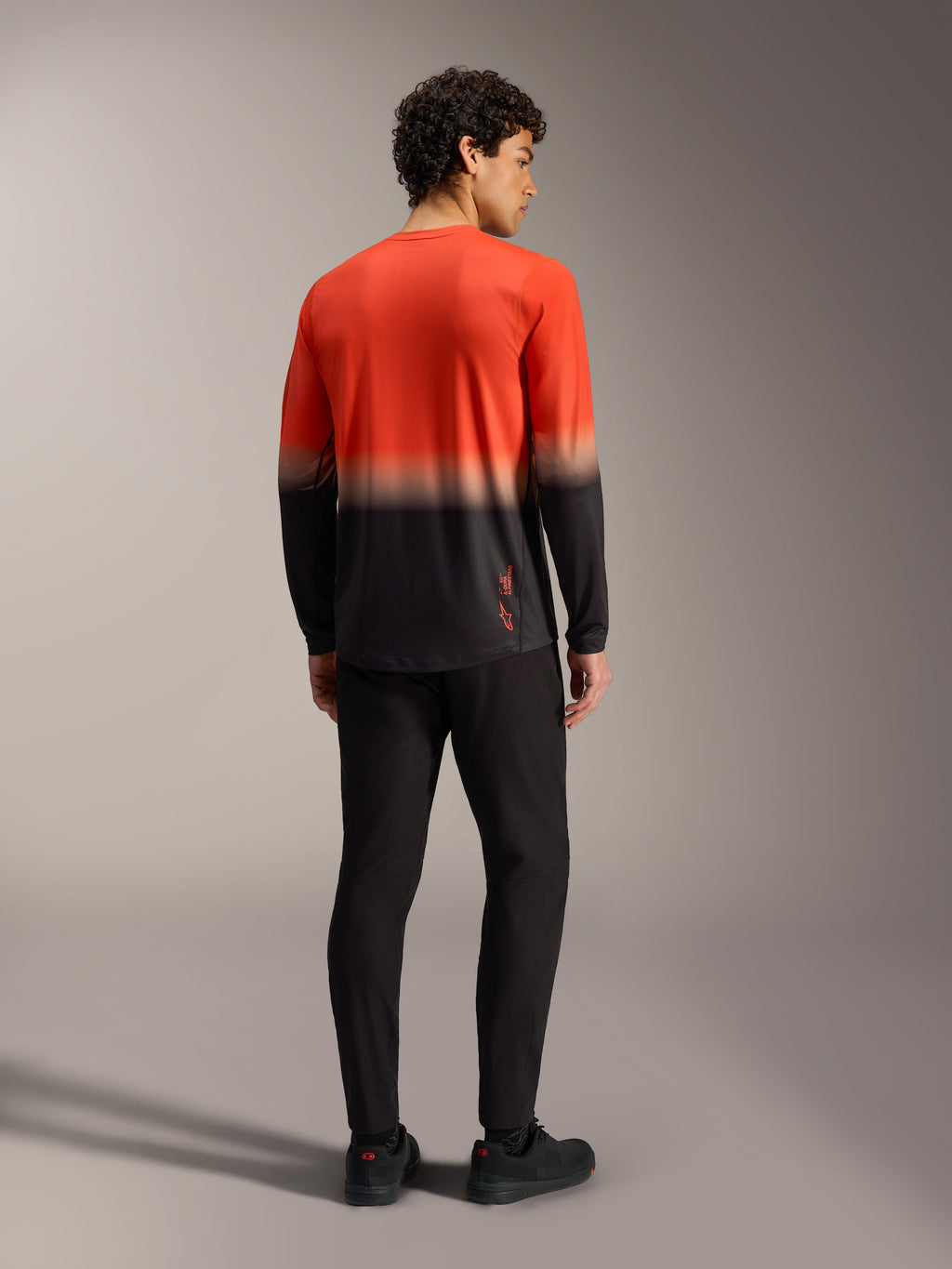 A-Dura ASTARS Jersey 2.0, långärmad mountainbiketröja i orange och svart gradient, sedd bakifrån.