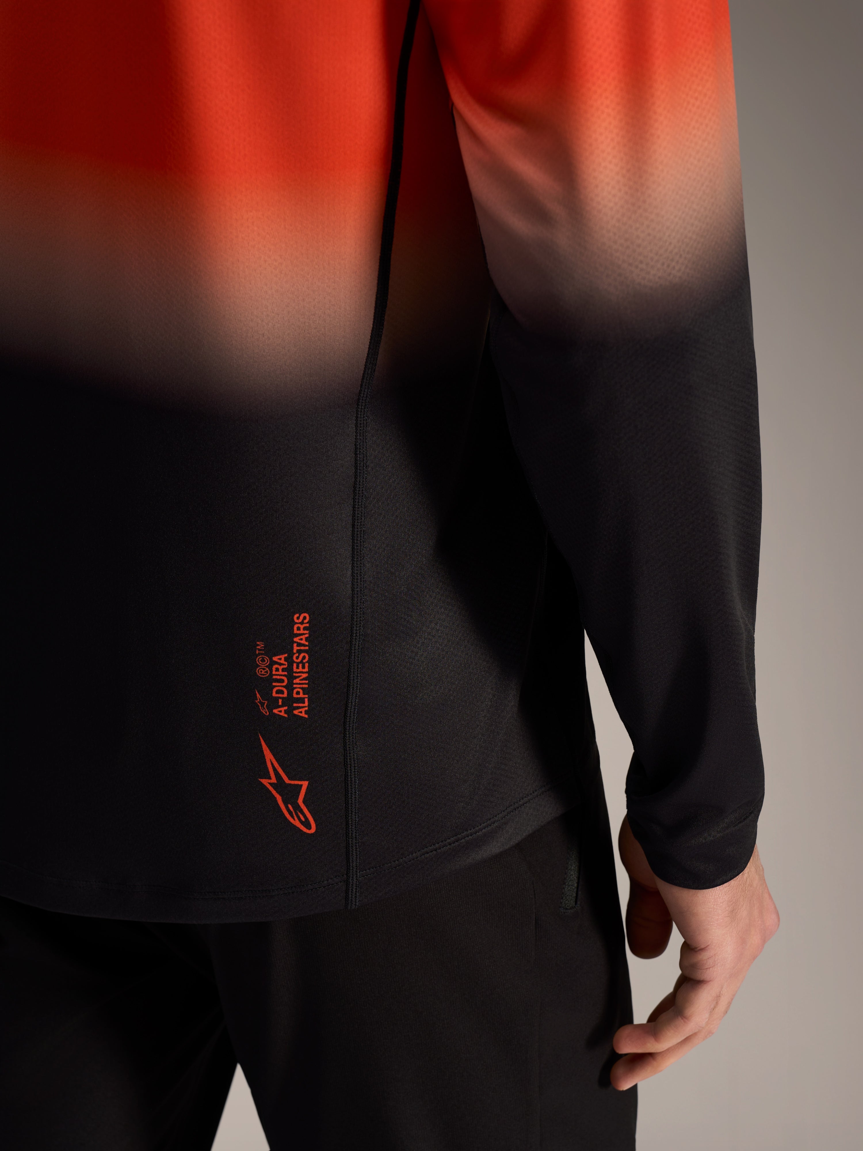 A-Dura ASTARS Jersey 2.0 i orange-svart gradient, logotyp på ländryggen och ventilerande jacquard-tyg.