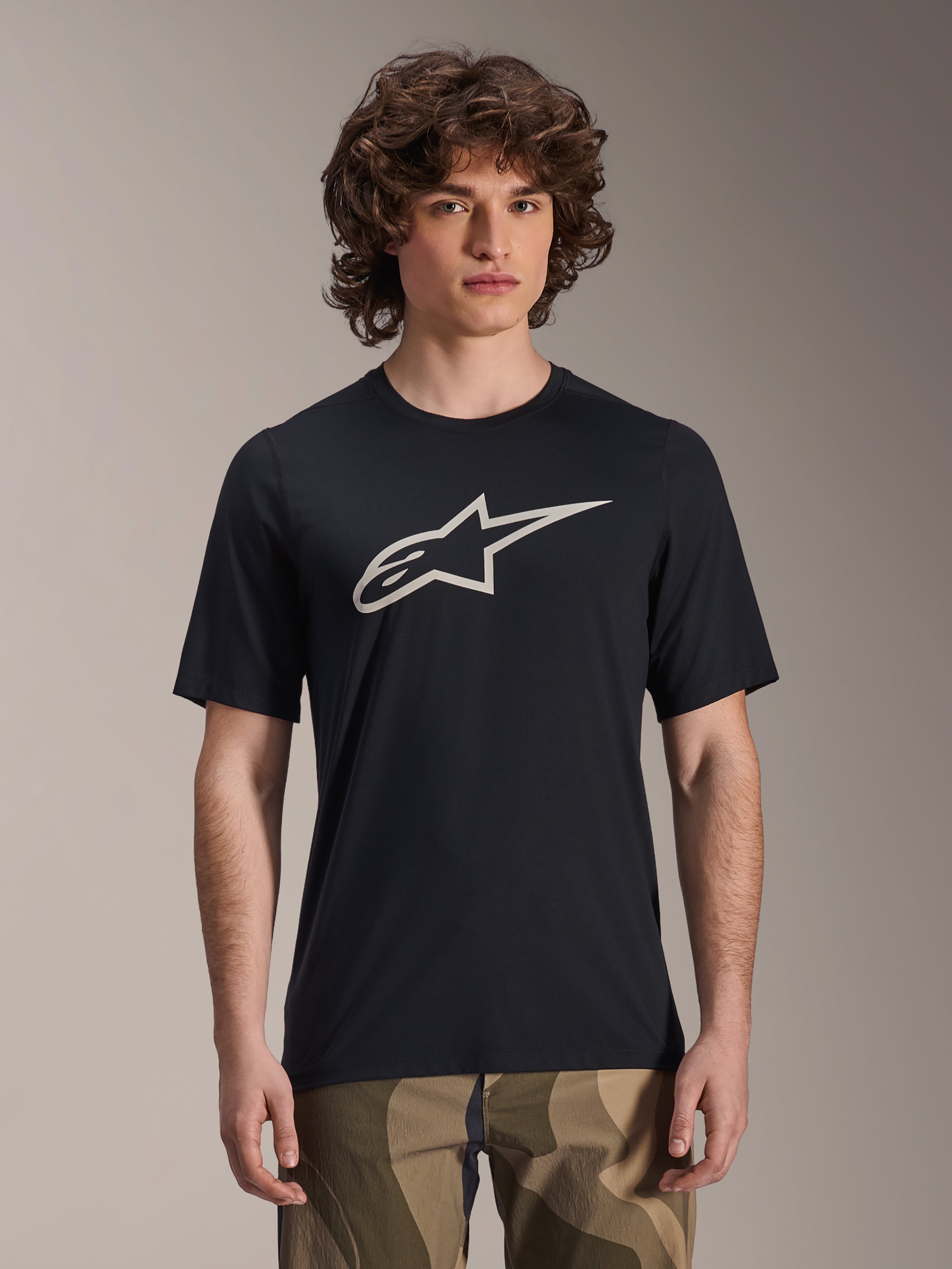 Alpinestars A-Dura Astar Jersey, kortärmad MTB-tröja, svart med vit stjärnlogotyp, bärs med kamouflagebyxor, lediga mountainbike-kläder, tekniskt fukttransporterande material