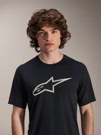 Alpinestars A-Dura Astar kortärmad tröja, svart, med en stor vit Astar-logotyp på bröstet, bärs av en manlig modell, avslappnade funktionskläder för mountainbike