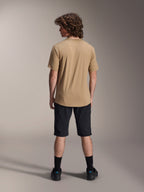 Manlig modell sedd bakifrån iförd Alpinestars A-Dura Liner Shorts i svart och en beige kortärmad tröja, kombinerat med svarta strumpor och skor, slitstarka mountainbike-kläder för terrängcykling