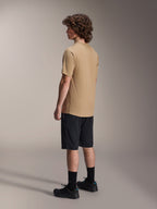 Alpinestars A-Dura Liner Shorts i svart och A-Dura SS Jersey i beige, bärs av en manlig modell sedd från sidan, matchade med svarta strumpor och cykelskor, livsstilskläder för mountainbike