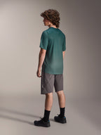 Alpinestars A-Dura Rise tröja, kortärmad MTB-tröja, Silver Pine-grön, bärs med grå shorts och svarta skor, vy bakifrån som visar förlängt bakstycke och normal passform, lätt fukttransporterande material för stigcykling