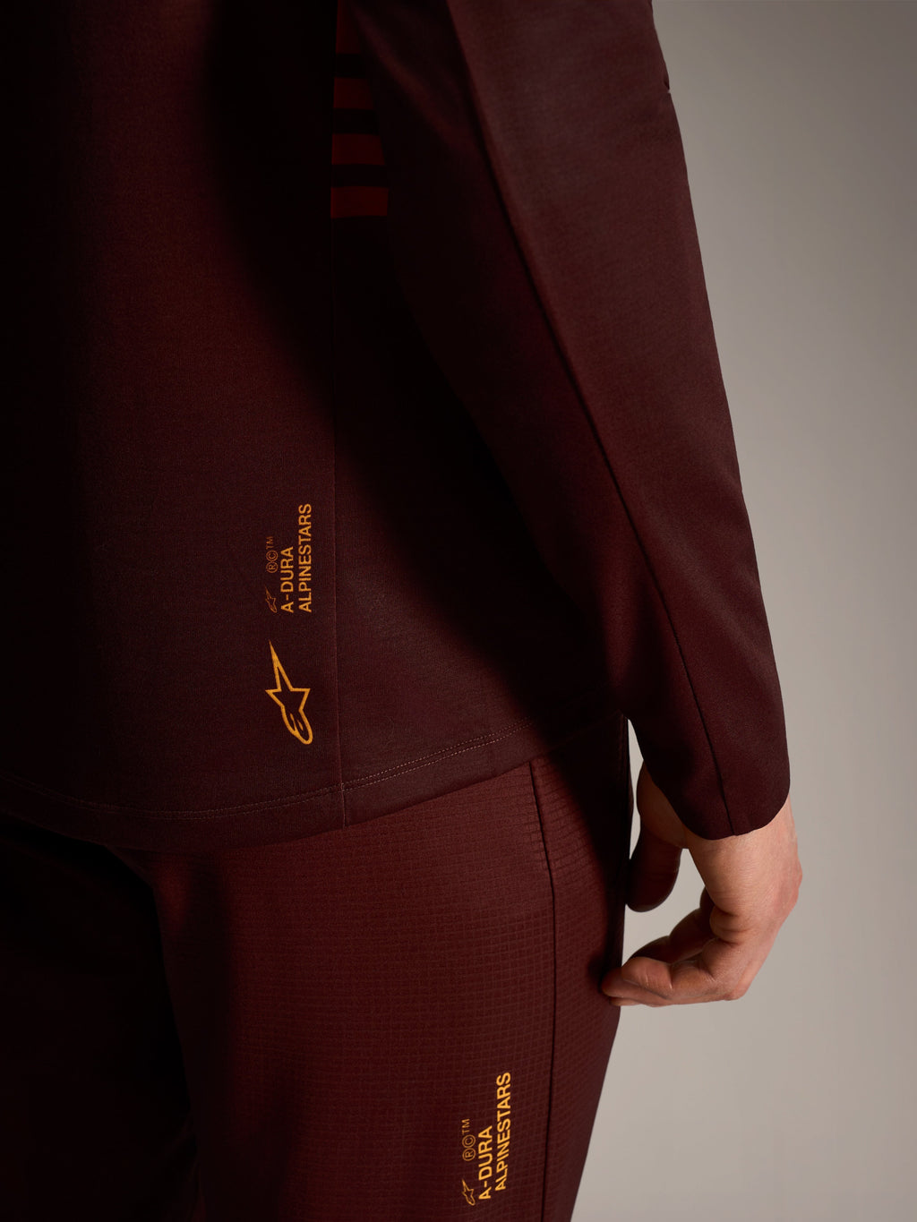A-Dura Elite långärmad tröja i bordeaux, gul Alpinestars-branding, teknisk trail-prestanda för cykling.