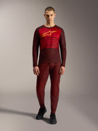 Alpinestars A-Dura Elite 2.0 långärmad tröja i bordeaux med gul bröstlogotyp och röda ränder.
