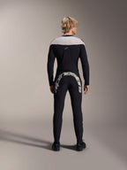 Alpinestars A-Supra Melt-byxor, svarta, baksida som visar det stora vita Alpinestars-ordmärket över bakoket, kombinerat med en matchande långärmad tröja och svarta cykelskor, högpresterande mountainbike-utrustning för terrängkörning.