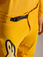 Alpinestars Limited Edition A-Supra Melt Gold Pants, Mountain Bike Pants, Dark Yellow, close-up of the black ratchet closure system at the waistband, featuring laser perforations on the inner thigh for ventilation