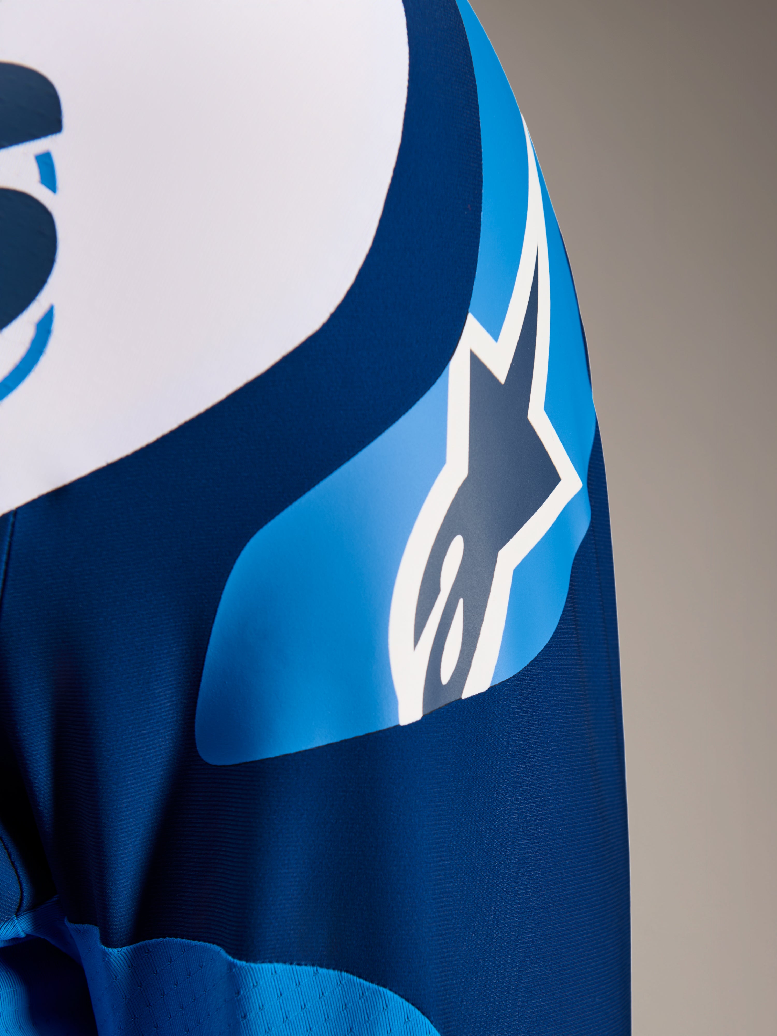 Alpinestars A-Supra Melt-tröja, långärmad MTB-tröja i blått, närbild på ärmen som visar ASTARS-logotypen och mikroperforerat material för ventilation