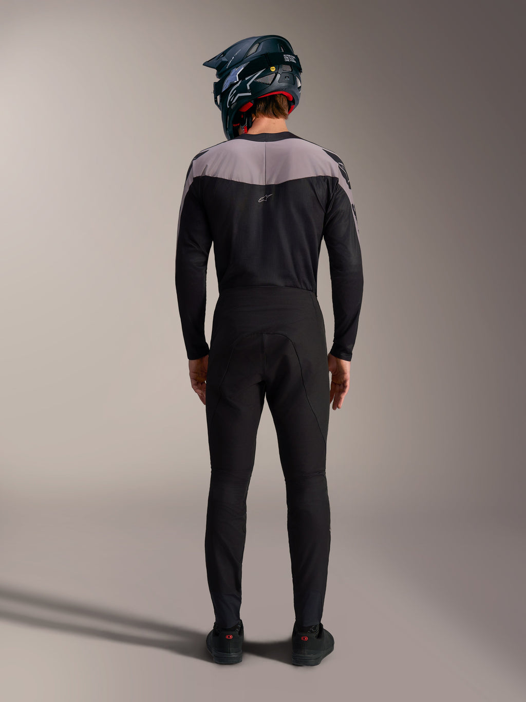 Alpinestars A-Supra Elite MTB-kit i svart med performance-byxor, tröja och fullfacehjälm, vy bakifrån.