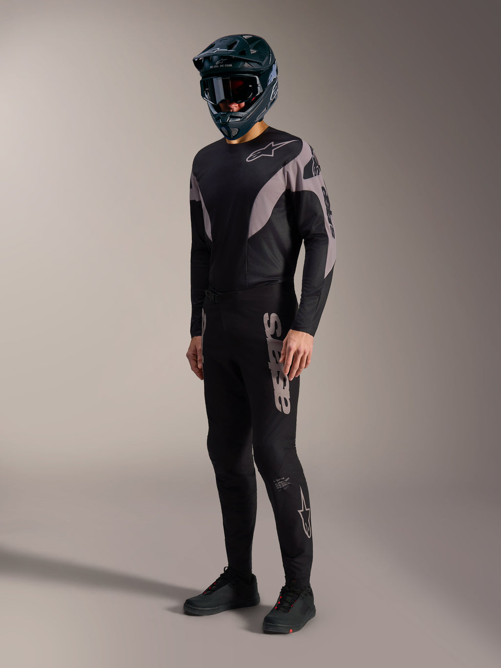 A-Supra Elite MTB-kit i svart och grått med stretchbyxor och tröja med framträdande Alpinestars-logotyper.