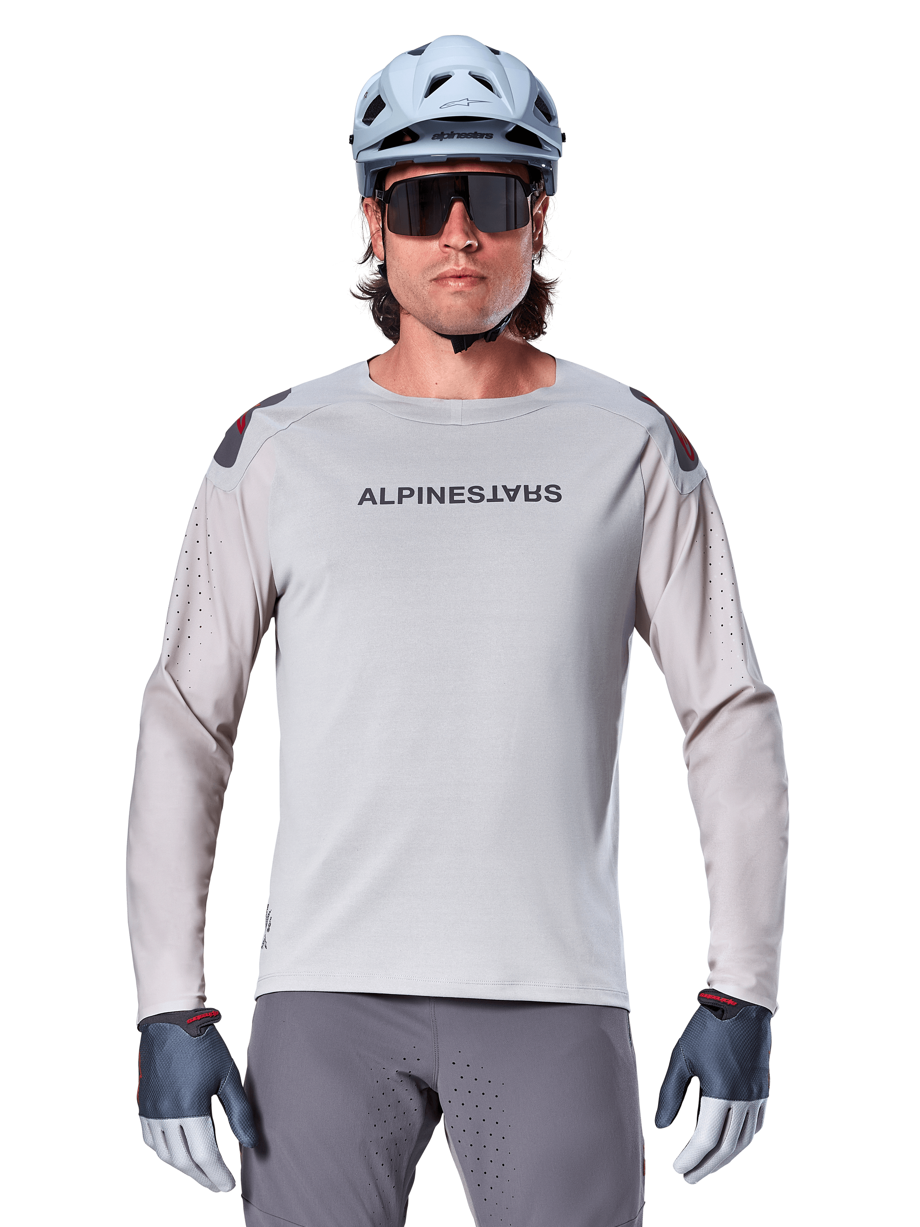 Alpinestars A-Aria Polartec Switch långärmad tröja, ljusgrå mountainbiketröja med laserperforeringar på ärmarna och logotyp på bröstet, bärs med ljusblå hjälm, solglasögon och grå handskar