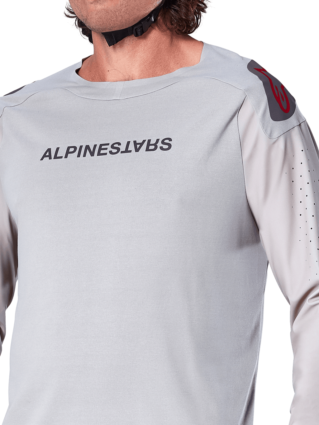Närbild på Alpinestars A-Aria Polartec Switch långärmad tröja i Light Gray, med Alpinestars logotyp på bröstet, röd logotyp på axeln och laserperforerade ärmar för luftflöde, premium mountainbike-utrustning