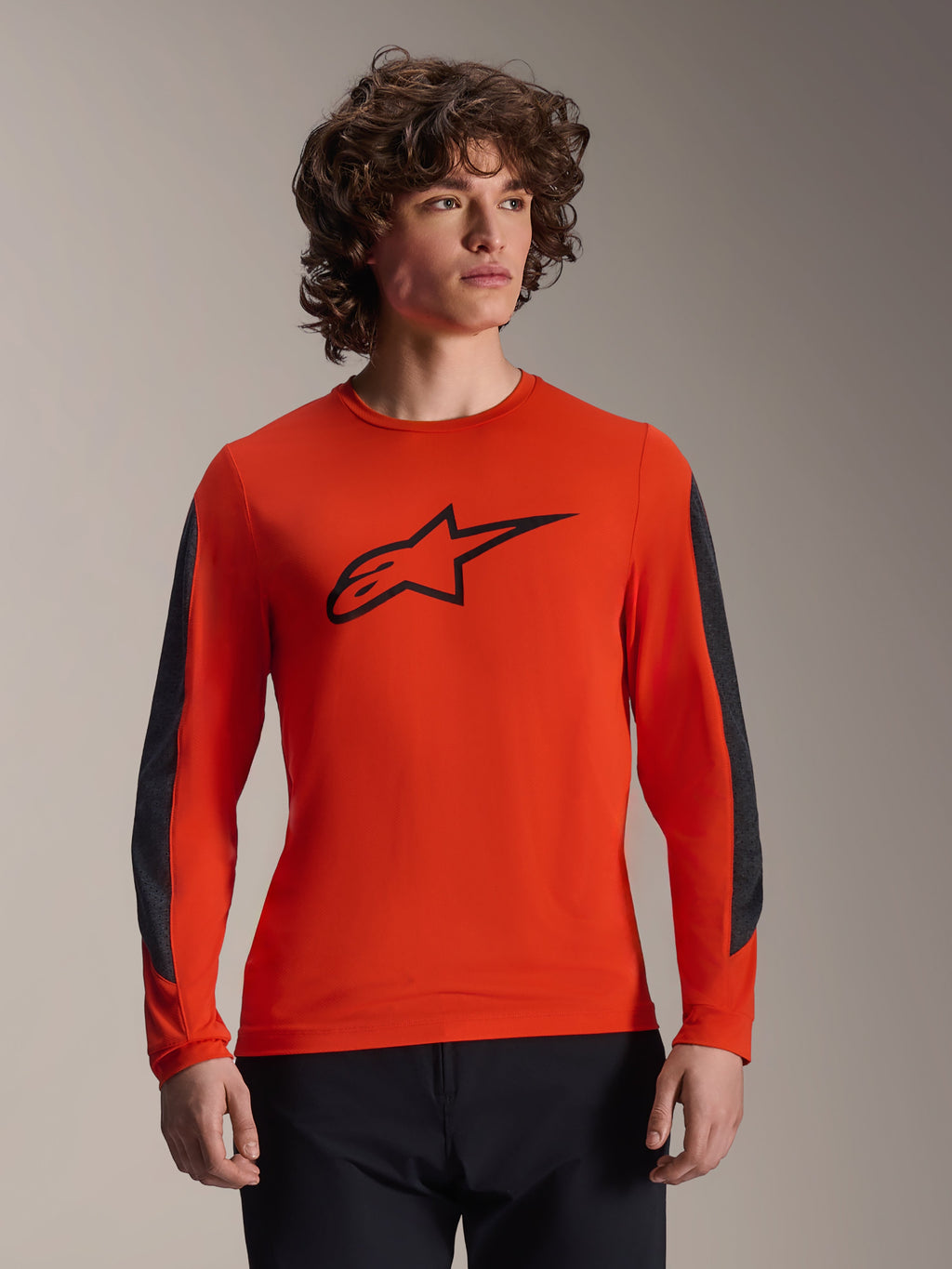 Alpinestars A-Dura Insert Astar Jersey – långärmad tröja, Spicy Orange med svart Astar-logotyp, mörkgrå slitstarka ärmpaneler, bärs av en manlig modell, teknisk MTB-cykeltröja