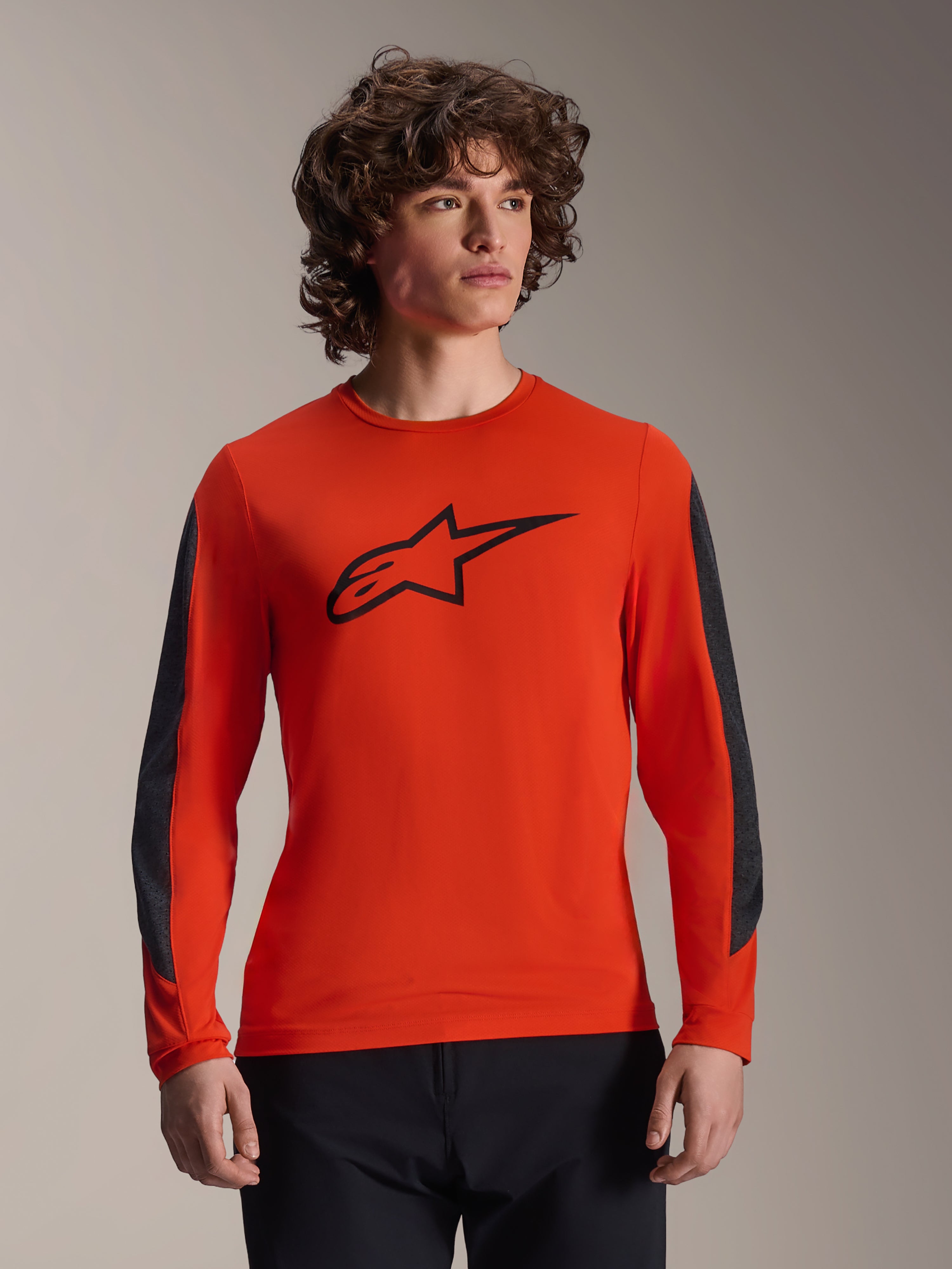 Alpinestars A-Dura Insert Astar Jersey – långärmad tröja, Spicy Orange med svart Astar-logotyp, mörkgrå slitstarka ärmpaneler, bärs av en manlig modell, teknisk MTB-cykeltröja
