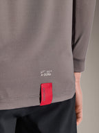Alpinestars A-Dura Insert Astar Jersey, långärmad MTB-jersey, mörkgrå, närbild på detalj av nedre fållen baktill med vit A-DURA-märkning och en karakteristisk röd ASTARS-tygetikett, texturerat funktionsmaterial