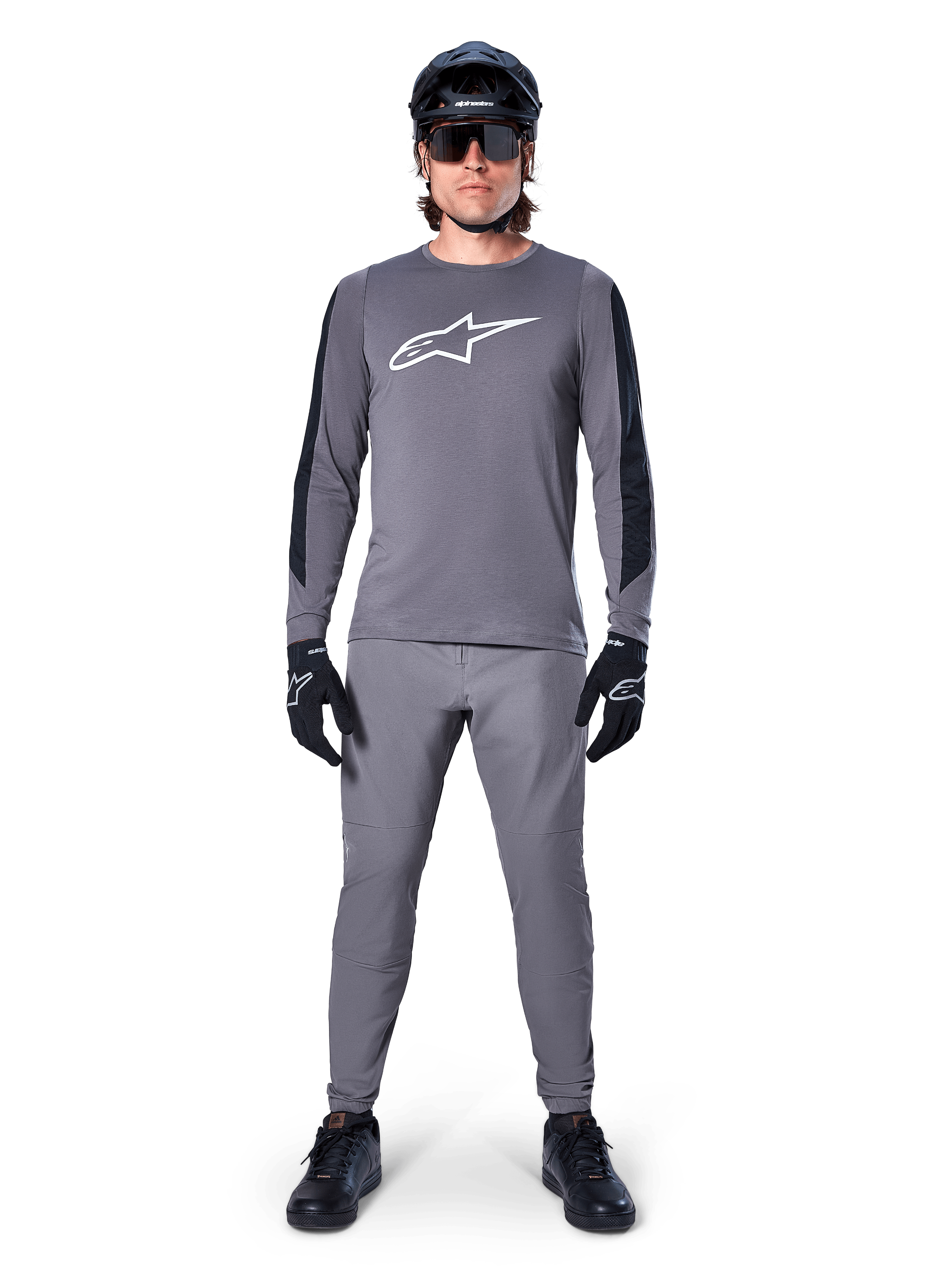 Alpinestars A-Dura Dri Astar-tröja, långärmad MTB-tröja i mörkgrått, med vit logotyp på bröstet och svarta paneler på ärmarna, bärs med matchande grå byxor, svart hjälm, solglasögon och handskar för en komplett outfit för terrängcykling