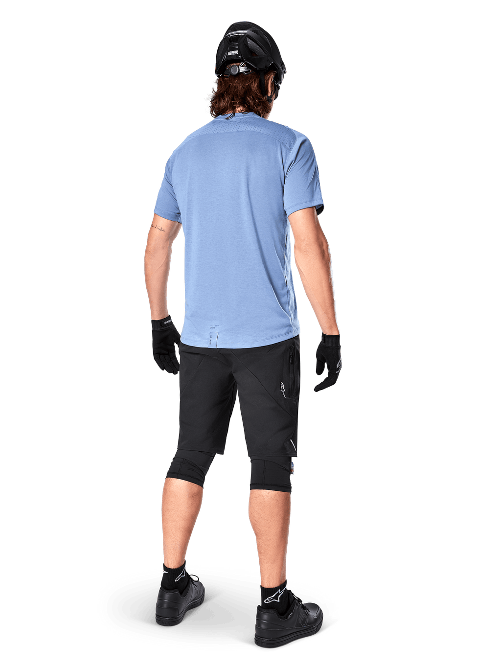 Alpinestars A-Dura Dri Astar kortärmad tröja, Infinity Blue, vy bakifrån, matchad med svarta mountainbikeshorts och hjälm, tekniska cykelkläder med fukttransporterande material och förlängd rygg